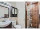 Well-lit bathroom with modern vanity, toilet, and a glass-enclosed shower with wood-look tile at 4075 E Oquendo Rd, Las Vegas, NV 89120