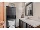 This bathroom has a dark cabinet with a white countertop, a framed mirror and decorative wall art at 4075 E Oquendo Rd, Las Vegas, NV 89120