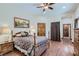 Cozy bedroom with wood floors, a bed with decorative pillows, and a view of the en suite bathroom at 4075 E Oquendo Rd, Las Vegas, NV 89120