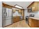 Well-lit kitchen features stainless steel appliances, wood cabinets, and granite countertops at 4075 E Oquendo Rd, Las Vegas, NV 89120