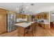 Modern kitchen with stainless steel appliances, a center island, wooden cabinets, and bar seating at 4075 E Oquendo Rd, Las Vegas, NV 89120