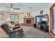 Comfortable living room with a brick fireplace, neutral carpet, and a ceiling fan at 4075 E Oquendo Rd, Las Vegas, NV 89120