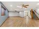 Open living area featuring wood-look tile flooring, ceiling fans, and staircase at 4075 E Oquendo Rd, Las Vegas, NV 89120