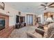 Cozy living room with a brick fireplace, plush carpeting, and a ceiling fan at 4075 E Oquendo Rd, Las Vegas, NV 89120