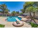 Inviting backyard pool with diving board, palm trees, rock features, and ample deck space at 4075 E Oquendo Rd, Las Vegas, NV 89120