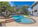 Lush backyard featuring a beautiful pool surrounded by mature palm trees and green grass at 4075 E Oquendo Rd, Las Vegas, NV 89120