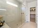 Modern bathroom featuring a glass-enclosed shower, sleek tiling, and access to a walk-in closet at 4230 E Brusca Way, Pahrump, NV 89061