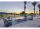 Outdoor fire pit with seating, landscaping, and distant views of trees and mountains at dusk at 4230 E Brusca Way, Pahrump, NV 89061