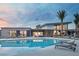 Community pool at dusk, featuring modern architecture, palm trees, and poolside lounge chairs at 4230 E Brusca Way, Pahrump, NV 89061