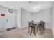 Bright dining room with tile floors, recessed lighting, chandelier, and a metal table with decorated black chairs at 4566 Ganier Ct # 1125, North Las Vegas, NV 89031