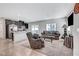 Bright open concept living area with dark cabinets in the kitchen, a comfortable sofa and arm chair at 4566 Ganier Ct # 1125, North Las Vegas, NV 89031