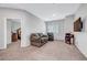 Inviting living room featuring neutral carpeting, ample seating, and a view to the bedroom at 4566 Ganier Ct # 1125, North Las Vegas, NV 89031