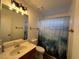 Bathroom vanity with mountain-themed shower curtain and modern lighting at 470 Como Ct, Henderson, NV 89015