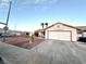 Exterior side view of single-story home with desert landscaping and attached garage, offering curb appeal at 470 Como Ct, Henderson, NV 89015