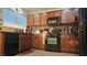 Well-lit kitchen with dark cabinetry, black appliances, and tile backsplash at 4928 Indigo Gorge Ave, Las Vegas, NV 89131