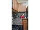 Close-up of kitchen countertop and cabinets with dark countertops and tile backsplash at 4928 Indigo Gorge Ave, Las Vegas, NV 89131