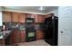 Traditional kitchen with dark cabinetry, tile backsplash, black appliances, and solid surface countertop at 4928 Indigo Gorge Ave, Las Vegas, NV 89131