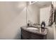 Elegant powder room with a marble countertop and decorative mirror at 5022 Arizo Ct, North Las Vegas, NV 89031