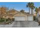 Single-story home with a three-car garage, desert landscaping, and mature palm trees under a blue sky at 5022 Arizo Ct, North Las Vegas, NV 89031