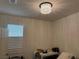 The empty bedroom has a modern light fixture and a large window at 5161 Birchland Manor Ave, Las Vegas, NV 89139