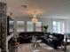 Bright living room featuring a dark leather sectional sofa and stylish crystal chandelier at 5161 Birchland Manor Ave, Las Vegas, NV 89139