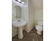 Cozy powder room with a pedestal sink, toilet, and modern flooring at 5212 Paradise Skies Ave, Las Vegas, NV 89156