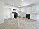 Modern kitchen with white cabinets, black appliances, and stylish herringbone flooring at 5212 Paradise Skies Ave, Las Vegas, NV 89156