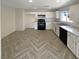 Well-lit kitchen featuring white cabinets, dark appliances, and stylish herringbone flooring at 5212 Paradise Skies Ave, Las Vegas, NV 89156