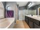 Bathroom featuring a double vanity, soaking tub, and a glass-enclosed shower at 58 Desert Sunflower Cir, Henderson, NV 89002