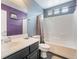 Bright bathroom featuring a shower-tub combo with white tile and a single sink vanity with gray cabinet at 58 Desert Sunflower Cir, Henderson, NV 89002