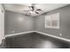 Bedroom featuring dark wood floors, gray walls, white trim, and a window with plantation shutters at 58 Desert Sunflower Cir, Henderson, NV 89002