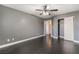 Bedroom showcasing dark wood floors, gray walls, white trim, closet and a doorway to another room at 58 Desert Sunflower Cir, Henderson, NV 89002