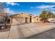 Single-story home featuring a three-car garage, desert landscaping, and blue skies at 58 Desert Sunflower Cir, Henderson, NV 89002