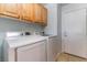 This laundry room features upper cabinets and modern white Samsung washer and dryer at 58 Desert Sunflower Cir, Henderson, NV 89002