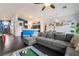 Open-concept living area with a gray sectional sofa, hardwood floors, and view into the kitchen and dining area at 58 Desert Sunflower Cir, Henderson, NV 89002