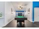 Bright game room with a pool table, hardwood floors, vibrant blue accent wall, and ample natural light at 58 Desert Sunflower Cir, Henderson, NV 89002