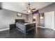 Well-lit bedroom with black wood floors, ceiling fan, and an ensuite bathroom at 58 Desert Sunflower Cir, Henderson, NV 89002