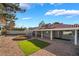 Picturesque backyard featuring a covered patio, gravel landscaping, and lush artificial turf at 60 Reyburn Dr, Henderson, NV 89074