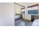 Bedroom featuring gray wood floors, large mirrored closet, and window with wood blinds at 60 Reyburn Dr, Henderson, NV 89074