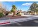 Beautiful single-story home with a tile roof, desert landscaping, and mature palm trees at 60 Reyburn Dr, Henderson, NV 89074