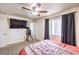 This bedroom features a ceiling fan, window and television at 6240 Clarice Ave, Las Vegas, NV 89107