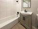 Stylish bathroom with tiled shower-tub combo, modern vanity with gray cabinets, and updated fixtures at 6421 Dinning Ave, Las Vegas, NV 89107