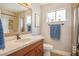 Updated bathroom with a wood vanity, framed mirror, and tiled shower at 6424 Old Colonial Way, Las Vegas, NV 89108