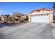 Single-story home features a wide driveway, desert landscaping, and a two car garage at 6424 Old Colonial Way, Las Vegas, NV 89108