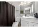 Cozy bathroom featuring a vanity with sink and cabinet space, plus a shower with black curtain at 6717 Atwood Ave, Las Vegas, NV 89108