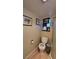 Bathroom with a toilet, framed wall art, and a small window at 701 Bourbon St # G3, Pahrump, NV 89048