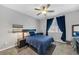 This cozy bedroom features dark-colored curtains and a ceiling fan at 7153 Tavita St, Las Vegas, NV 89113