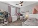 A pink and grey decorated bedroom with a ceiling fan at 7153 Tavita St, Las Vegas, NV 89113