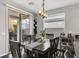 Dining room with modern chandelier, lots of light from the sliding door to the backyard and the window at 7153 Tavita St, Las Vegas, NV 89113