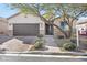 Charming home with a desert-landscaped yard and a paved driveway leading to the garage at 7153 Tavita St, Las Vegas, NV 89113